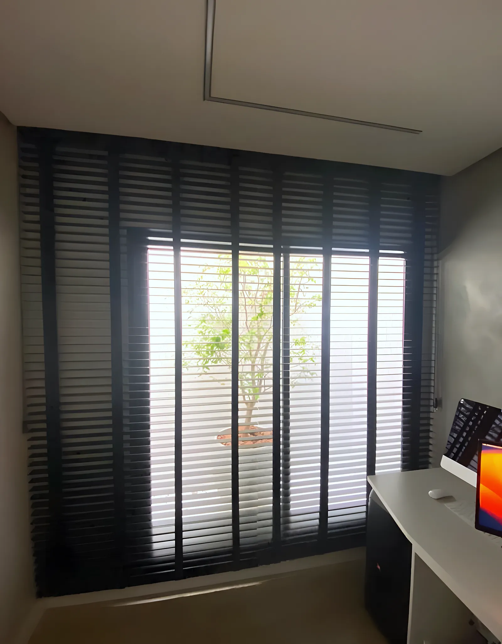 Persiana horizontal preta de 50 mm aberta em janela alta de home office, em Feira de Santana